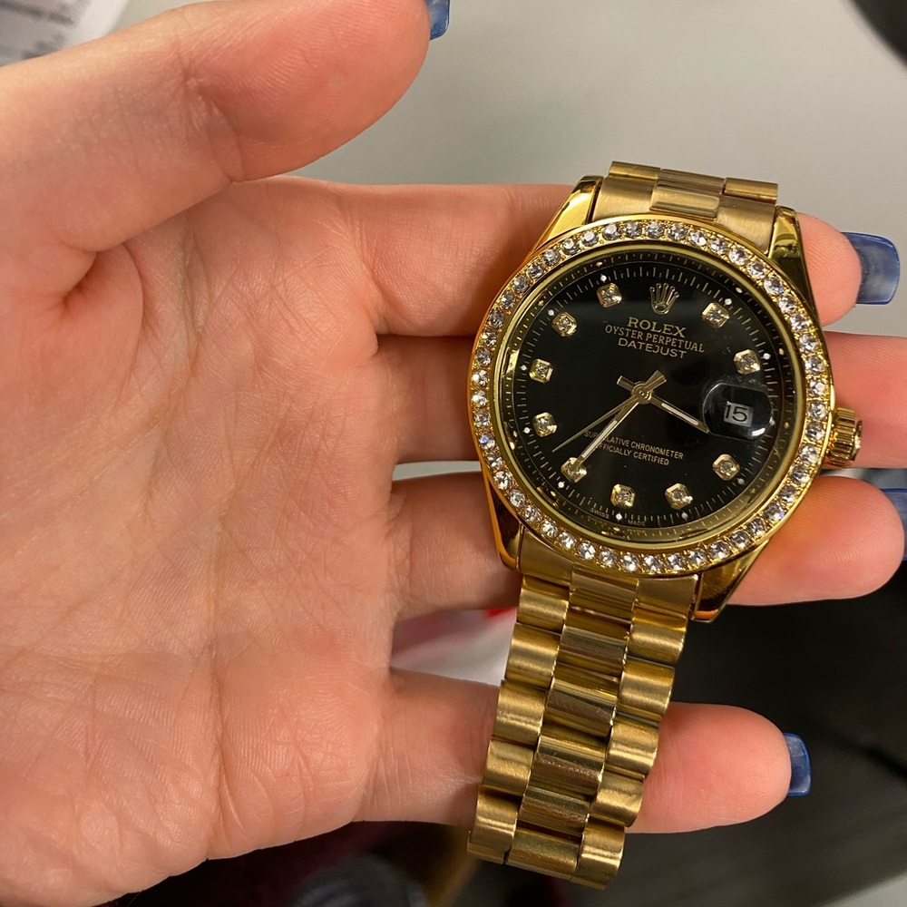 gold men’s watch with black face